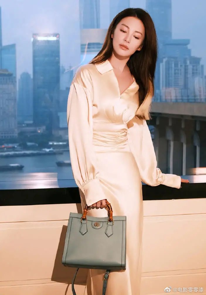 张雨绮晒出一组写真她穿了一件米黄色的丝绸长款连衣裙