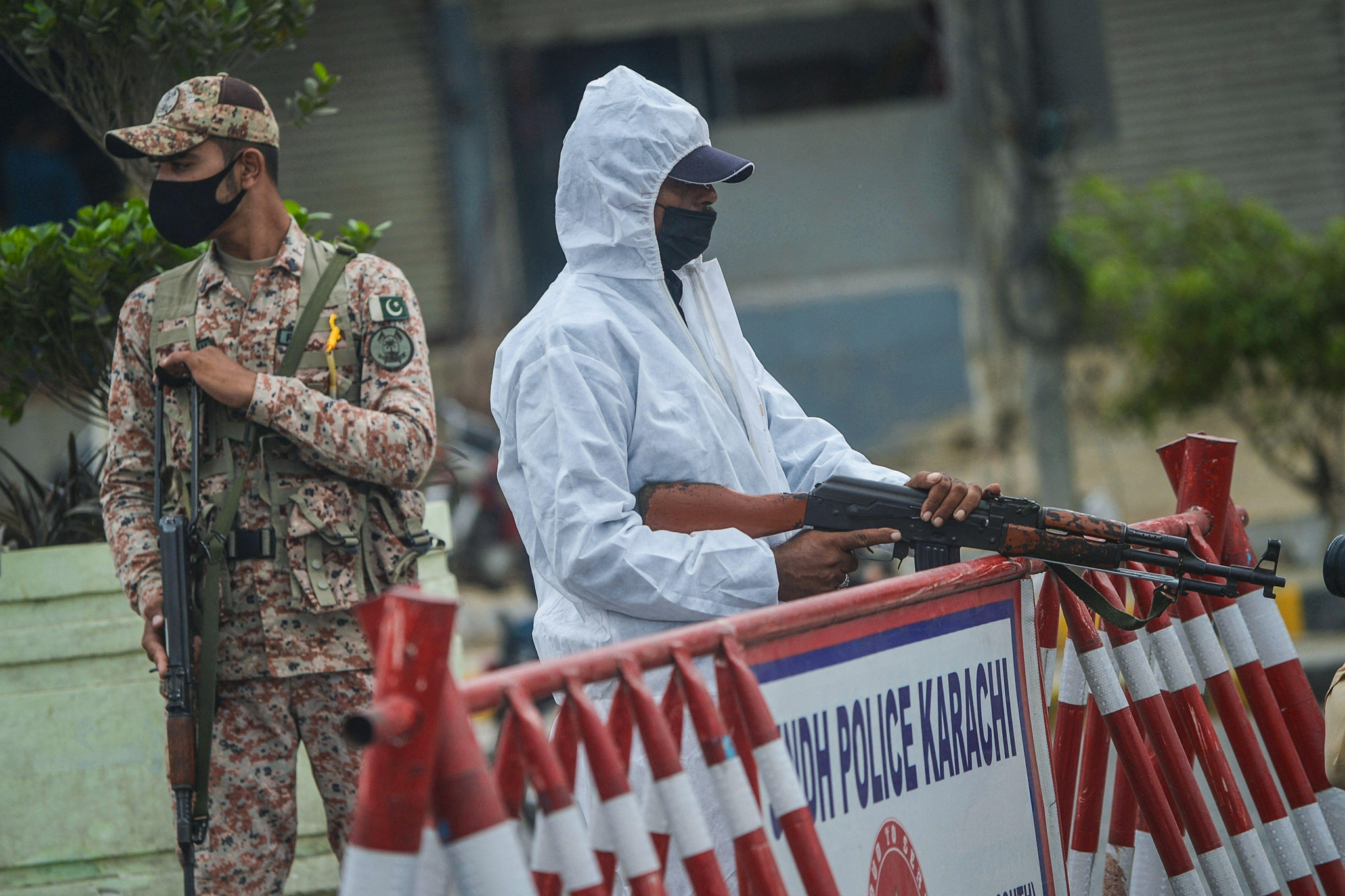 8月2日,警察身穿防护服在巴基斯坦卡拉奇街头一处安全检查点警戒.
