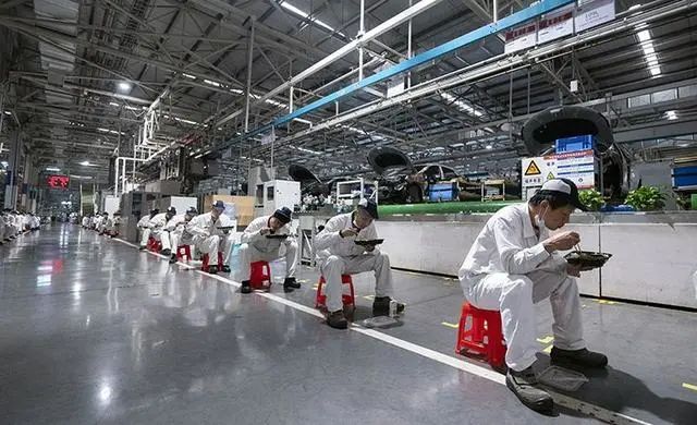 ▲武汉东风本田二厂，工人们间隔1.5米，在生产线旁吃午餐（新京报摄于2020年3月）