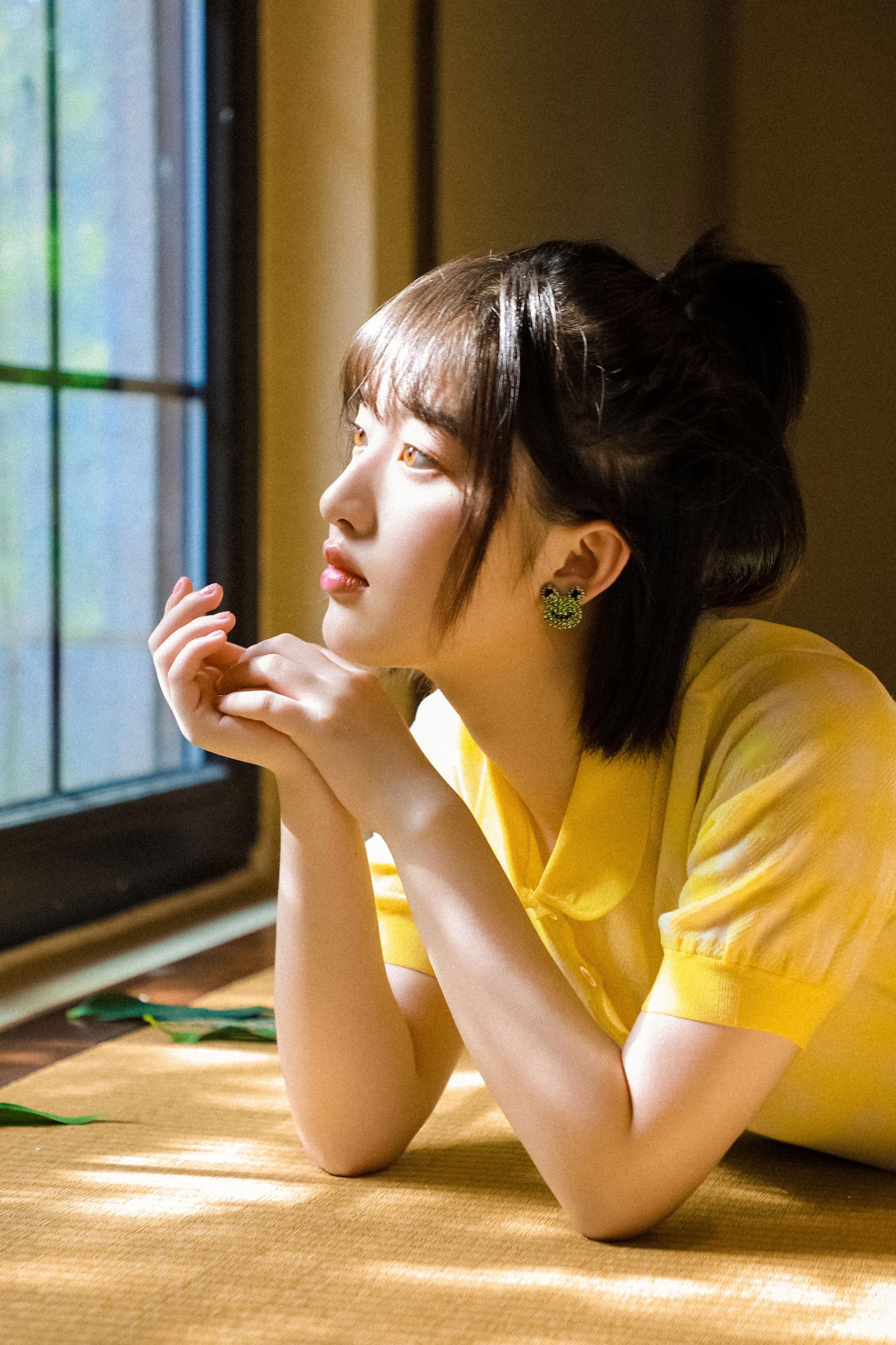 夏日元气少女邓恩熙上线手执花朵悠闲置身于窗前