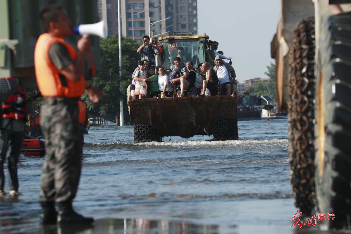2021年7月26日,抗洪一线官兵在河南省新乡卫辉市紧急转运群众.