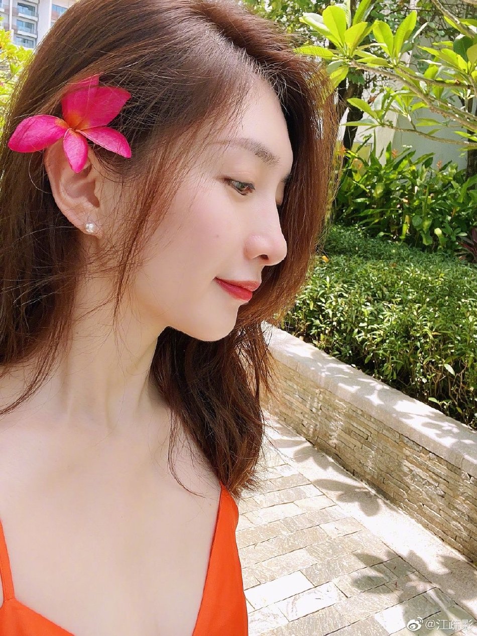 江疏影夏日度假随拍,她身穿吊带橙色长裙,卷发红唇