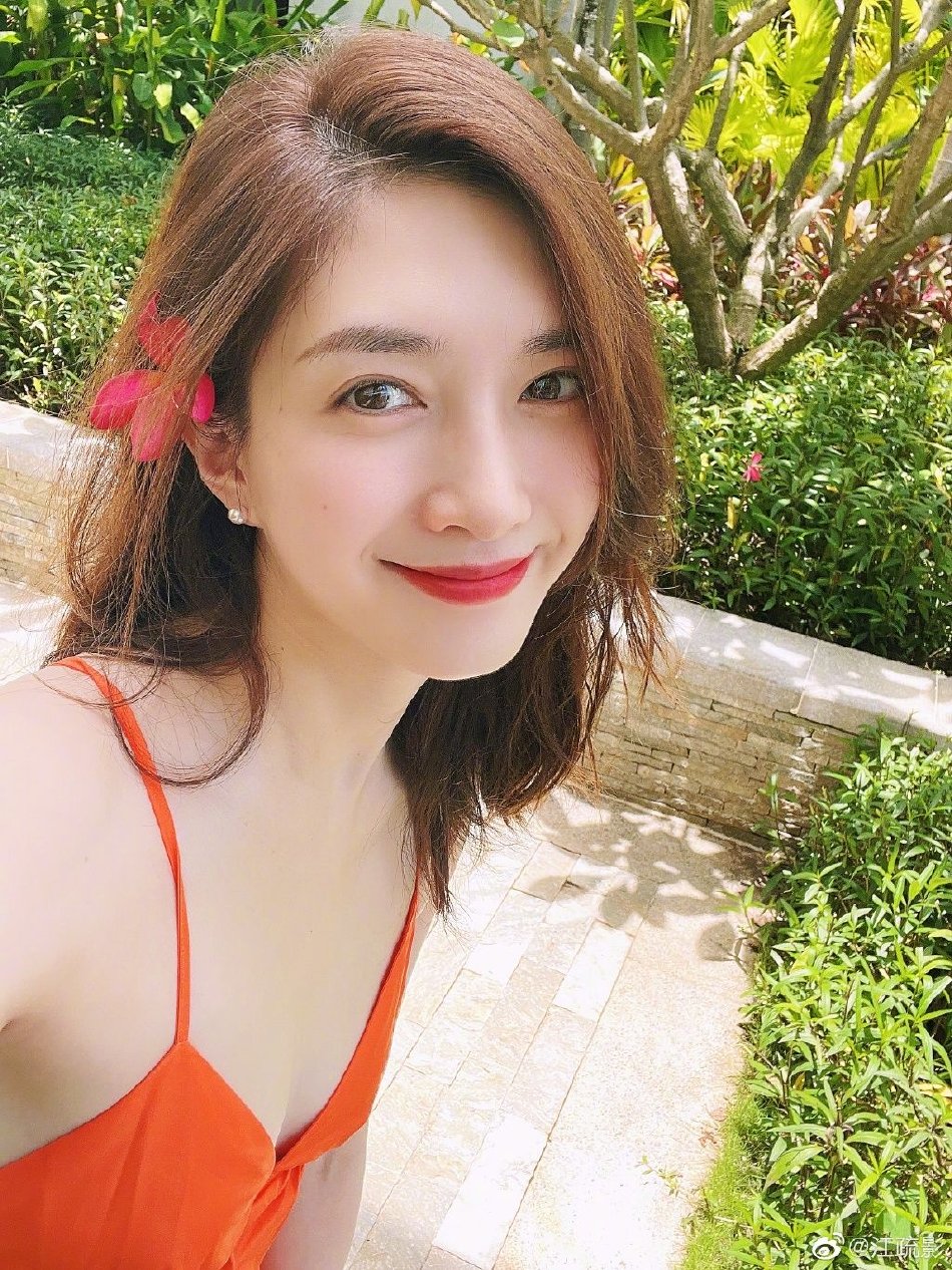 江疏影夏日度假随拍,她身穿吊带橙色长裙,卷发红唇