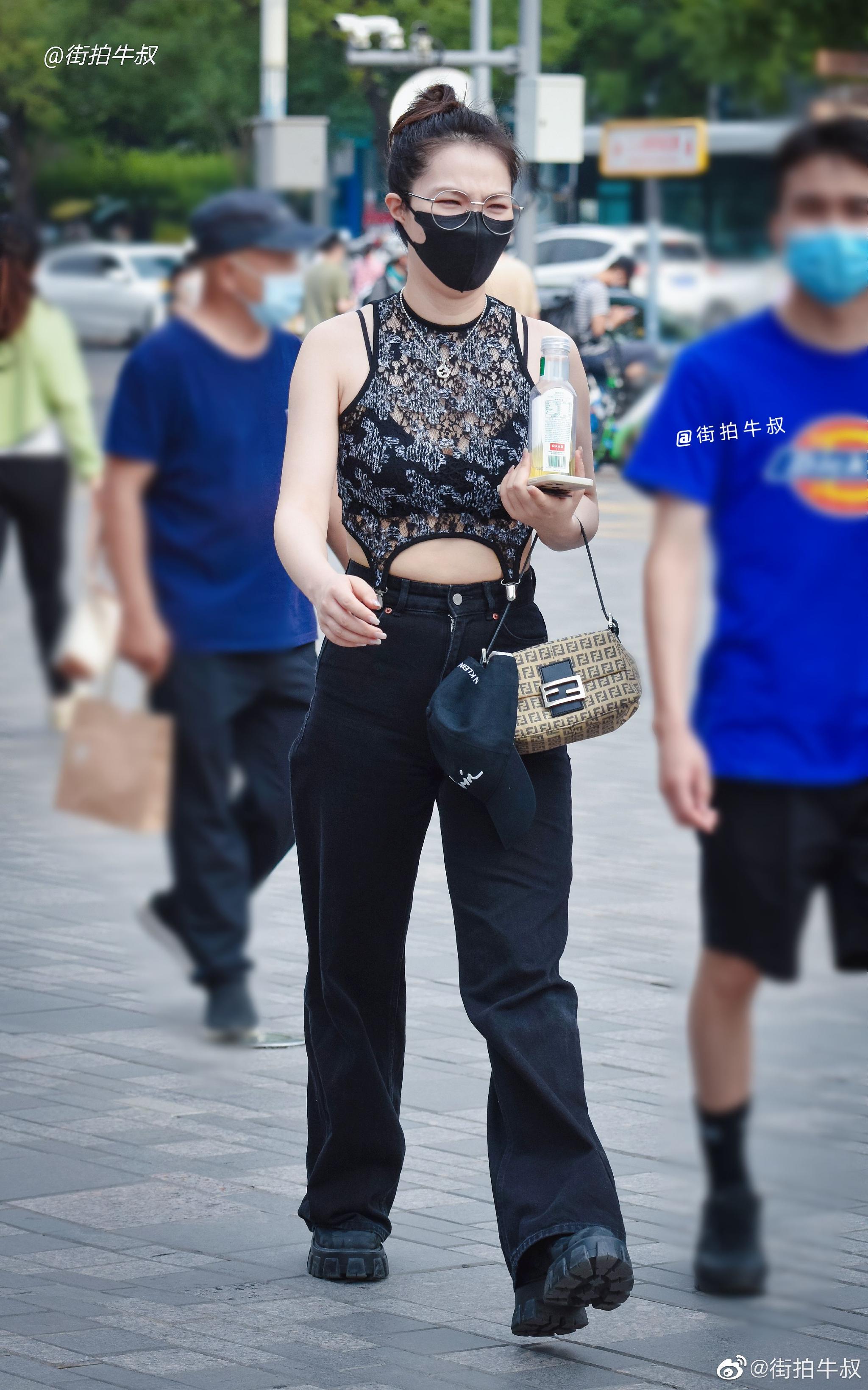 美女穿着吸睛的蕾丝镂空背心出街