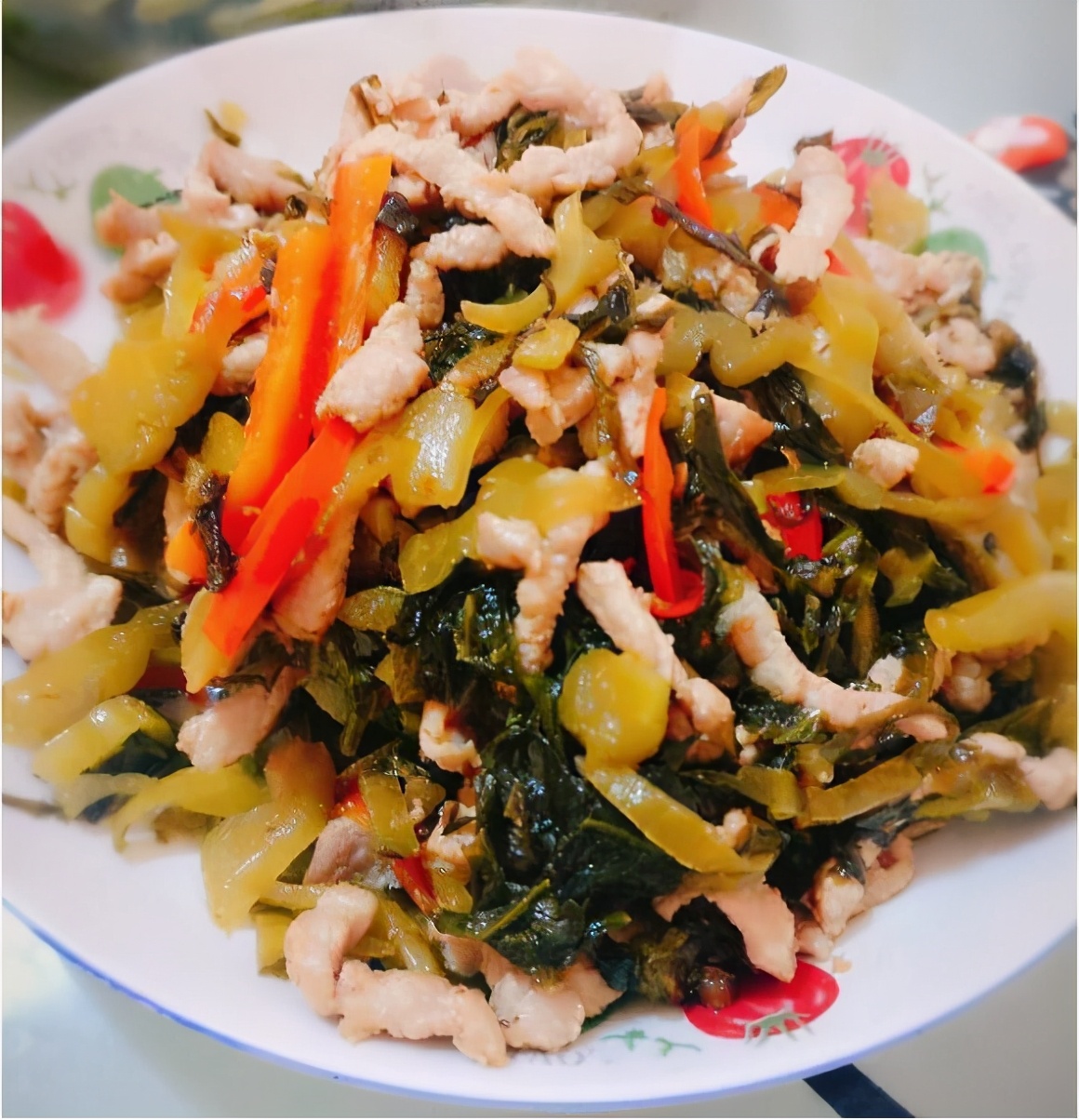 酸菜炒肉丝3,炒锅下油烧至七成热,下泡姜,炮红椒,蒜末炒香,下莴笋片