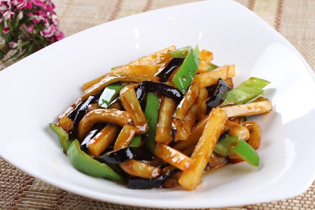 首先把茄子清洗干净,然后再切成菱形的小块,把青辣椒去掉辣椒籽也切成