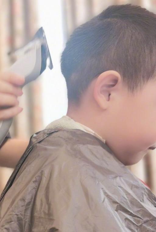 佟丽娅为儿子理发动作专业表情严肃朵朵乖巧端坐小动作显紧张