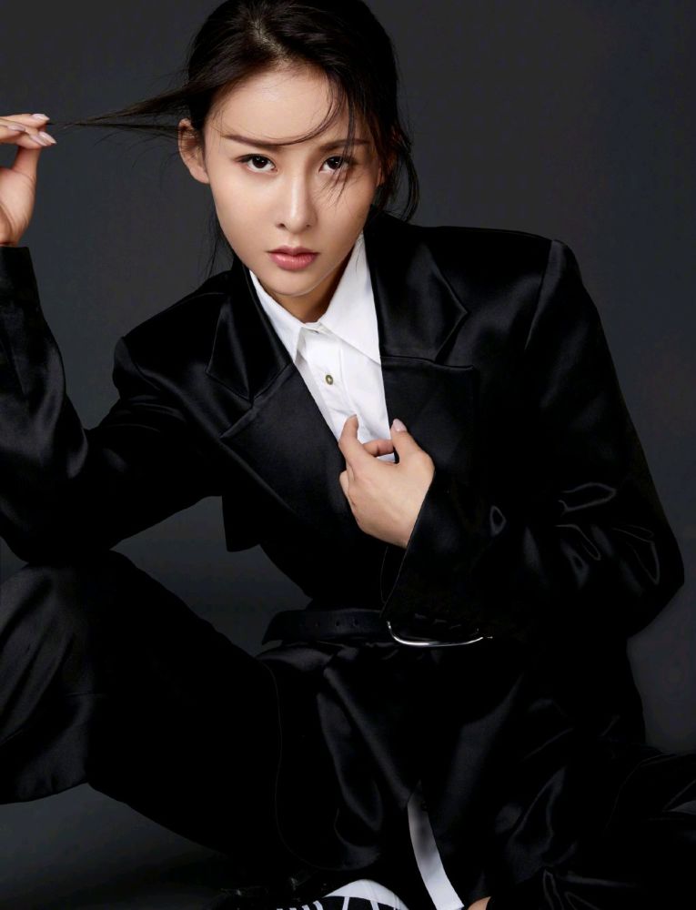 贾青身穿黑色针织衫搭配错位蓝色牛仔裤,休闲又时尚