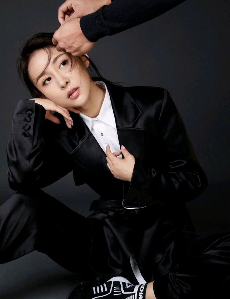 贾青身穿黑色针织衫搭配错位蓝色牛仔裤,休闲又时尚