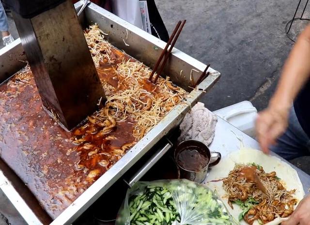 中年大叔摆摊做卷饼一张饼卷满菜只要7元一出摊就有人来排队