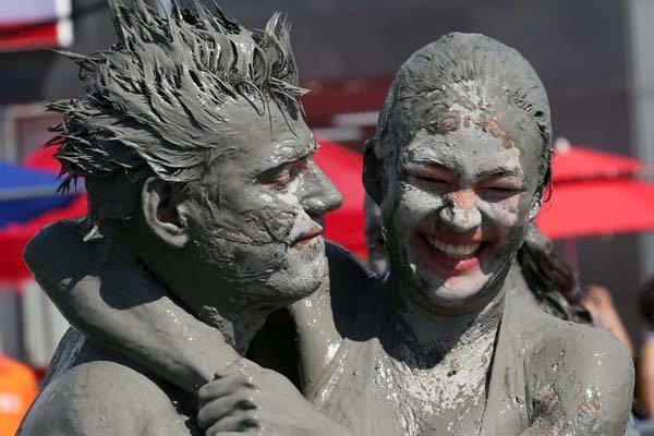 以色列美女泥巴大战身穿泳衣互抹泥巴吸引众多男游客