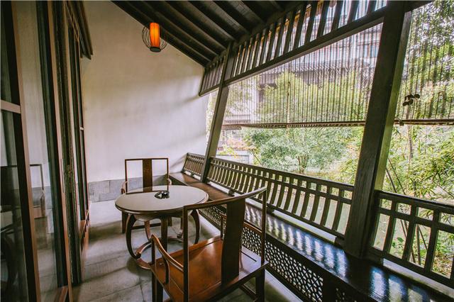 露台便是酒店的园林景色,坐在木椅子上听水流潺潺,欣赏江南园林中的一