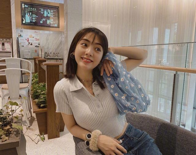 白色针织衫虽然是衬衫领的设计,但是解开纽扣,像v领的设计,让邢菲的