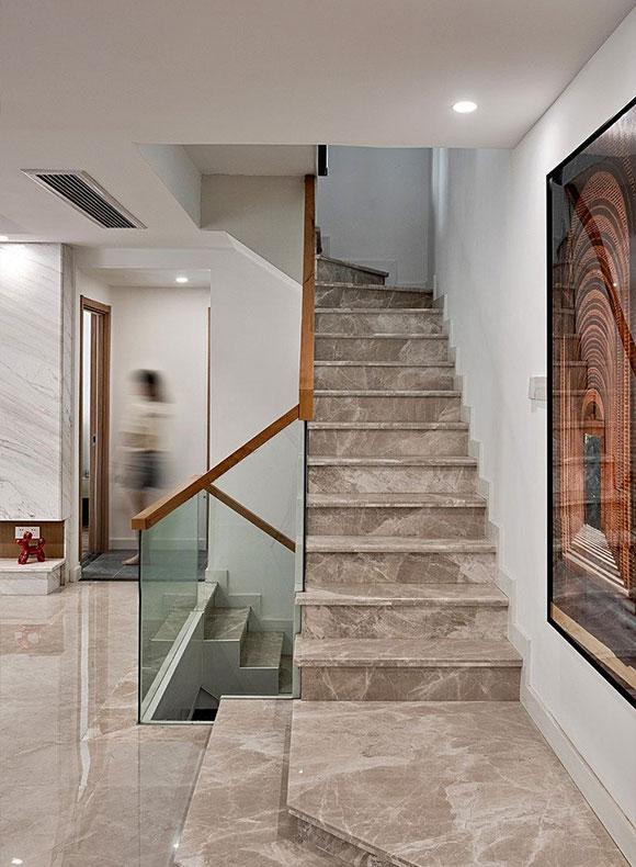 现代风格别墅装修胡桃木加玻璃的楼梯扶手,纹理感很强的石材台阶,或许