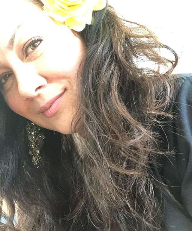 曝光的近照中,顶着一头长卷发的李香凝,头戴大黄花,对着镜头微笑着