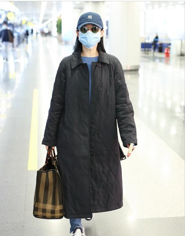谭卓穿黑色长款棉衣内搭蓝色针织衫,洋溢帅气感,又不失大气!