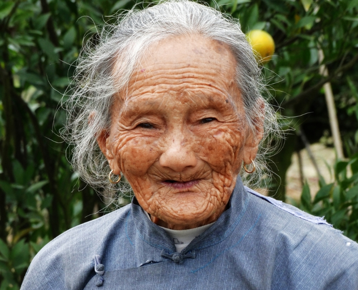 刚下到半山腰,就见一个六十多岁的老阿婆坐在路边,冲着他笑.