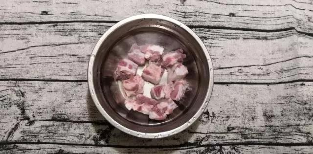 换一盆水,倒入1勺白醋,泡20分钟左右,排骨变白,倒掉水,把排骨洗干净后