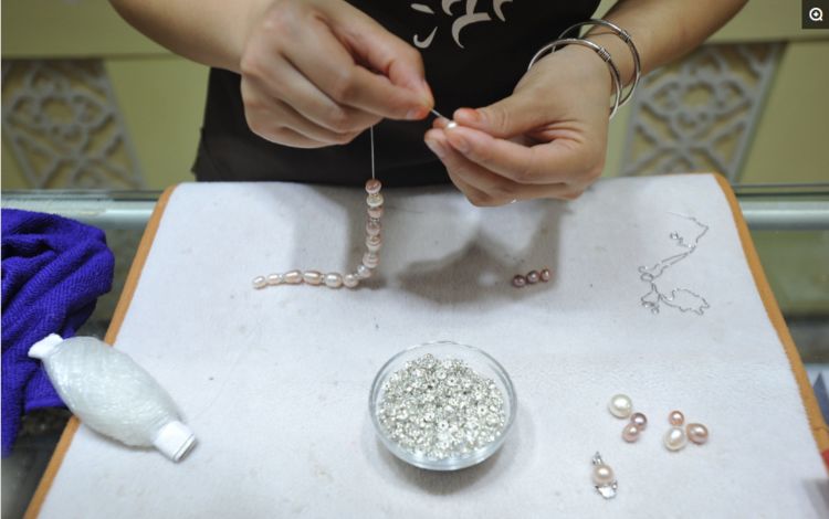 大街上现场开蚌取珍珠,一只蚌售价30元,3只蚌可做一条项链