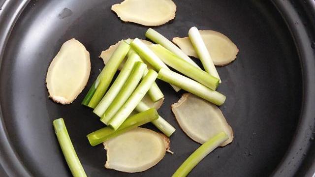 第三步:砂锅中放姜片和葱段铺在锅底一层.