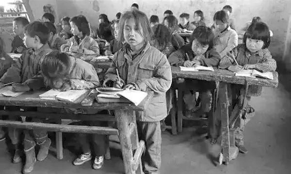 老照片:再穷不能穷教育,扛着桌凳去上学
