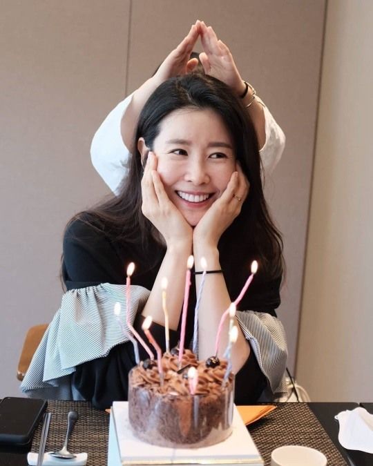 照片中李泰兰面前摆着漂亮的蛋糕,从开朗的笑容就可以看出幸福满溢