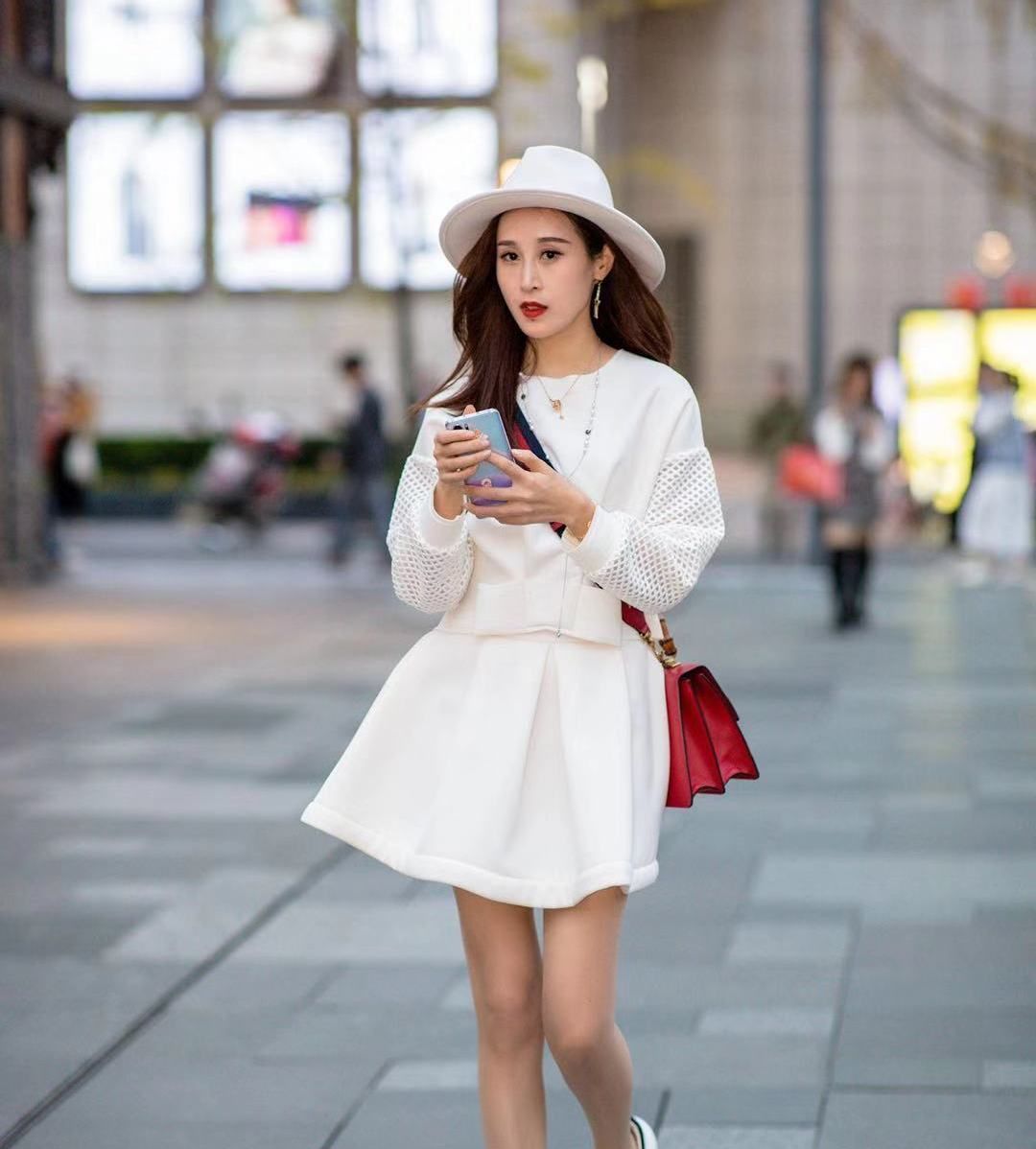 小姐姐一身白色短裙搭配同色圆帽,长发飘飘美丽动人