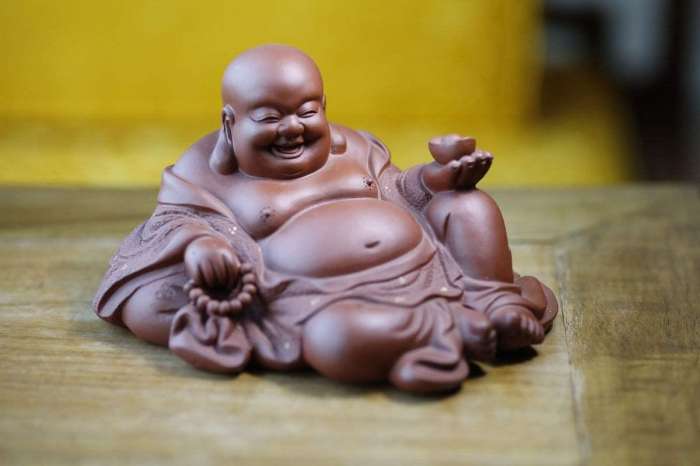 真人版"弥勒佛",表演坐着笑,观众看到后,纷纷朝其扔钱讨吉利