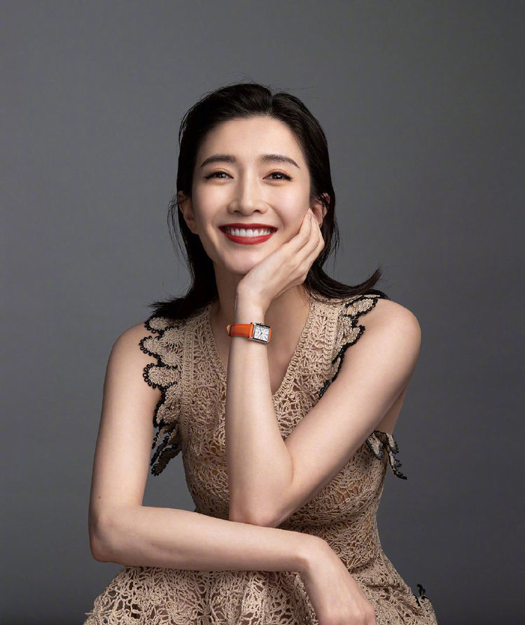 江疏影笑起来也是非常迷人的哟,穿了件镂空裁剪的吊带裙,有花边装饰在