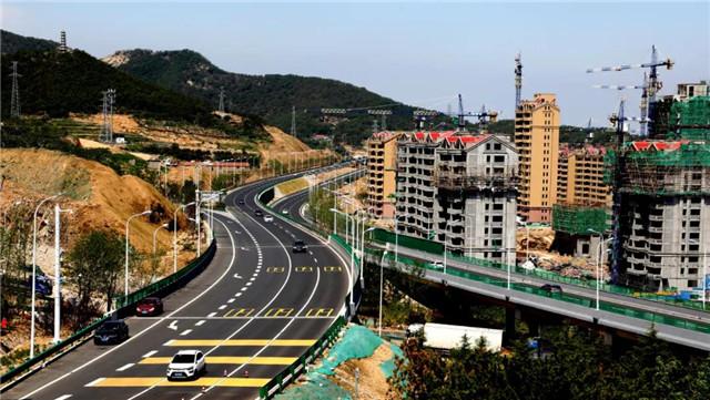 在华夏路至齐鲁大道辅路,几台摊铺机和压路机正在施工作业,摊铺沥青