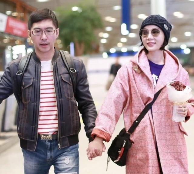陈数携老公走机场穿粉色长外套显温柔笑容娇羞看着不像42岁