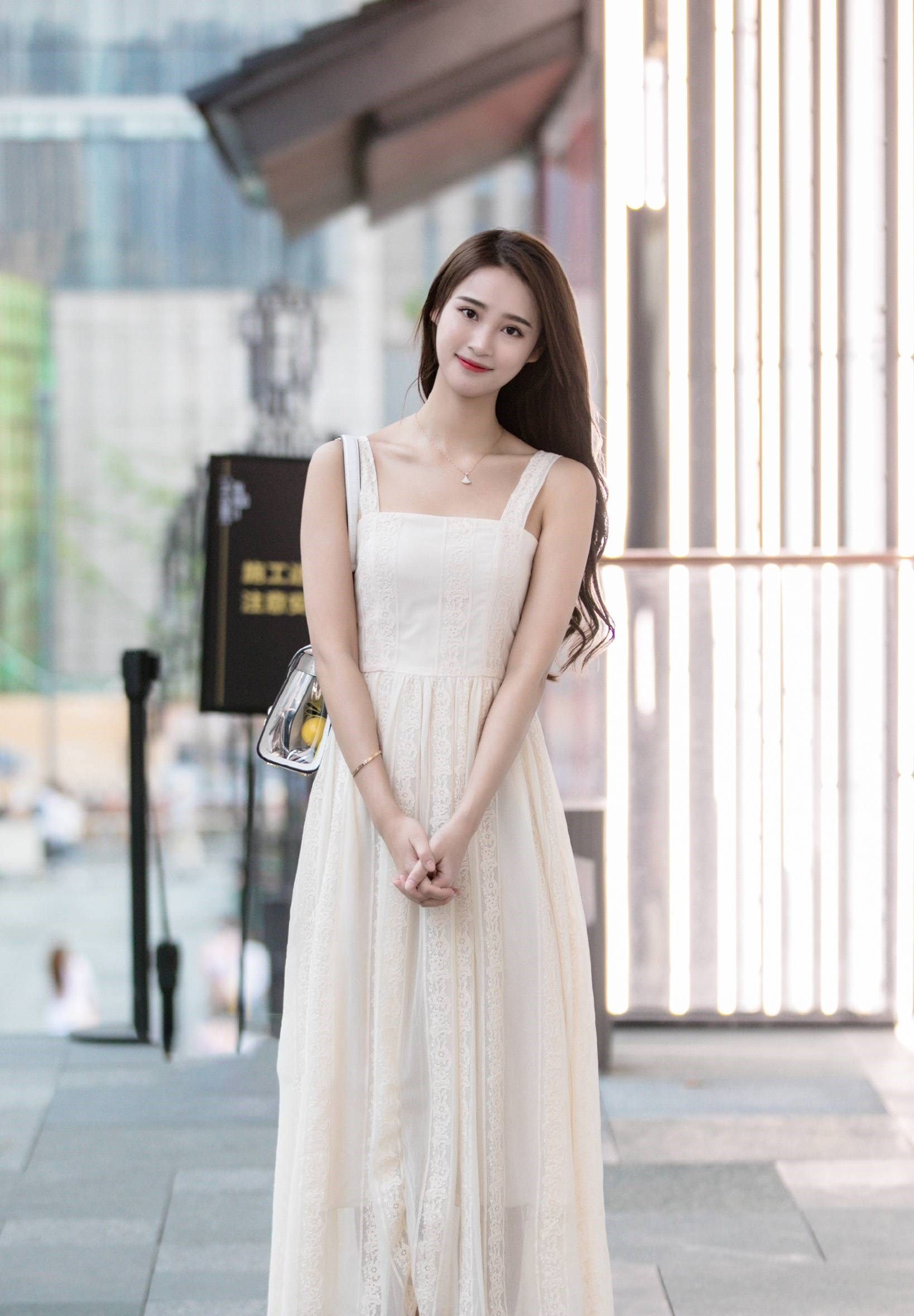 小姐姐身穿一款米白色的吊带长裙,款式简约大方