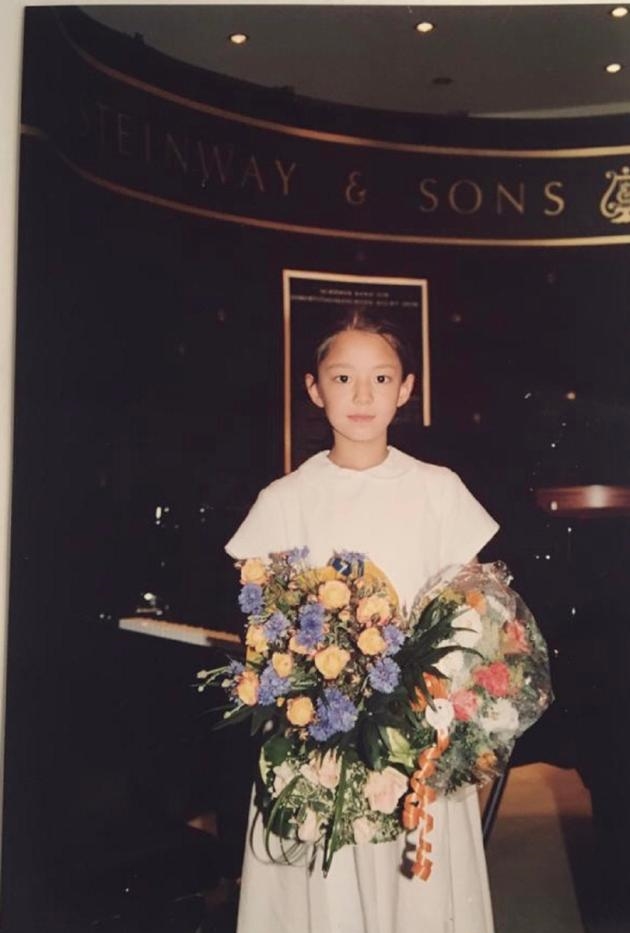 郎朗妻子吉娜分享童年演出照 穿白连衣裙捧花束清纯可爱