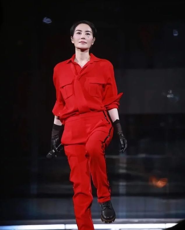 黑色亮面皮衣搭配上荧光粉色的半身裙,颜色虽靓丽耀眼,王菲也轻松hold