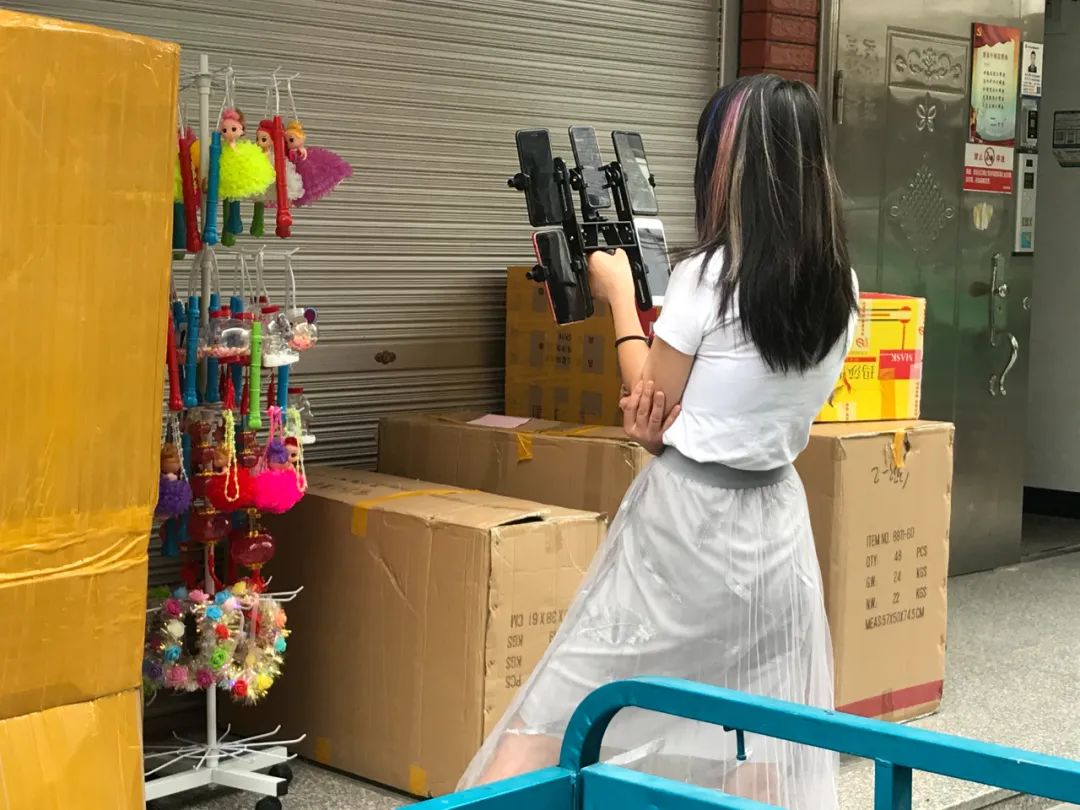 同时开着五台手机直播的店主。新京报记者王昱倩摄