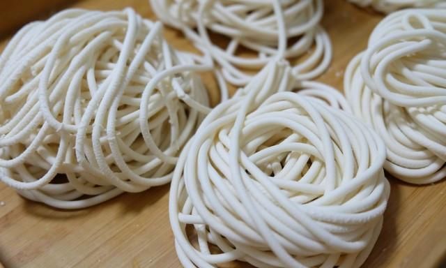 步骤8:很快面条机的出口就会挤出面条了,我用的是圆粗孔,做炸酱面喜欢