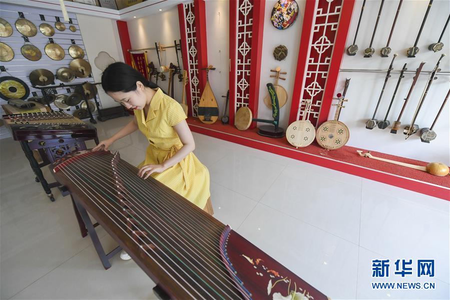 在饶阳县大官亭镇民族乐器产业园一家乐器厂展厅,调音师在调试古筝