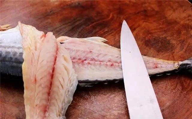 一直切到鱼肚上面,鱼头扔掉不要,接着把鲅鱼的另外一面,用同样的方法