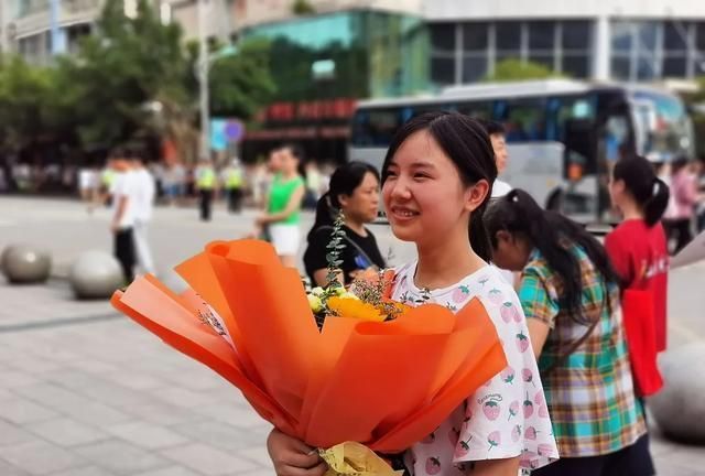 广安市邻水实验学校考点的考生,怀抱家长送来的鲜花,脸上绽放灿烂的