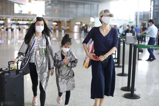 马伊琍带两个女儿走机场,穿蓝色衬衫配半身裙 小白鞋,简洁大气