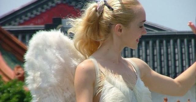 为了飞翔,一个女人在背上插了只翅膀,飞行很神奇