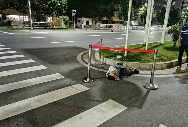 郑州街头奇闻趣事一男子烂醉如泥倒路边好心人用围栏对其保护