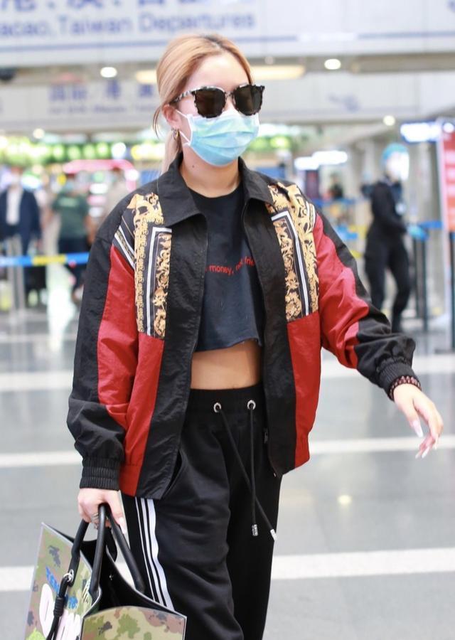 王菊穿运动装走机场,慵懒造型太中性,抬起胳膊的瞬间却显女人味