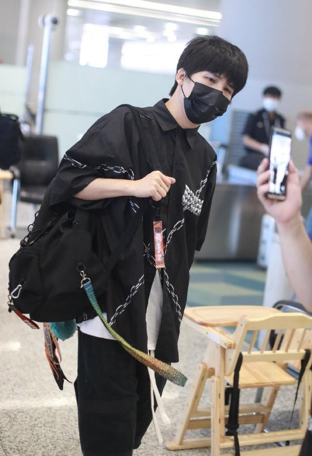 36岁大张伟低调走机场,穿印花t恤搭配锁链衬衫,顺毛发型有点乖