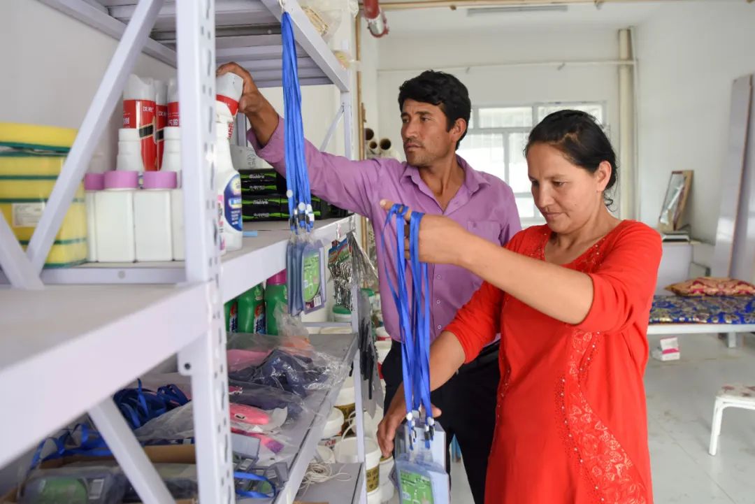 买合肉甫·木拉吧(左)和妻子热娜古丽·喀尔曼在自家的建材商店里整理