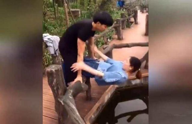 情侣公园游玩热吻秀恩爱两人你侬我侬时一激动双双掉下桥