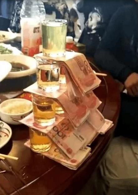 土豪同学把酒摆成了一座小山,每一层都放上了厚厚一沓子钱,他表示