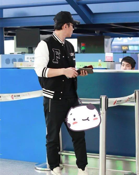 罗晋身穿拼色刺绣棒球夹克下身穿束口休闲裤,脚踩字母印花高帮小白鞋