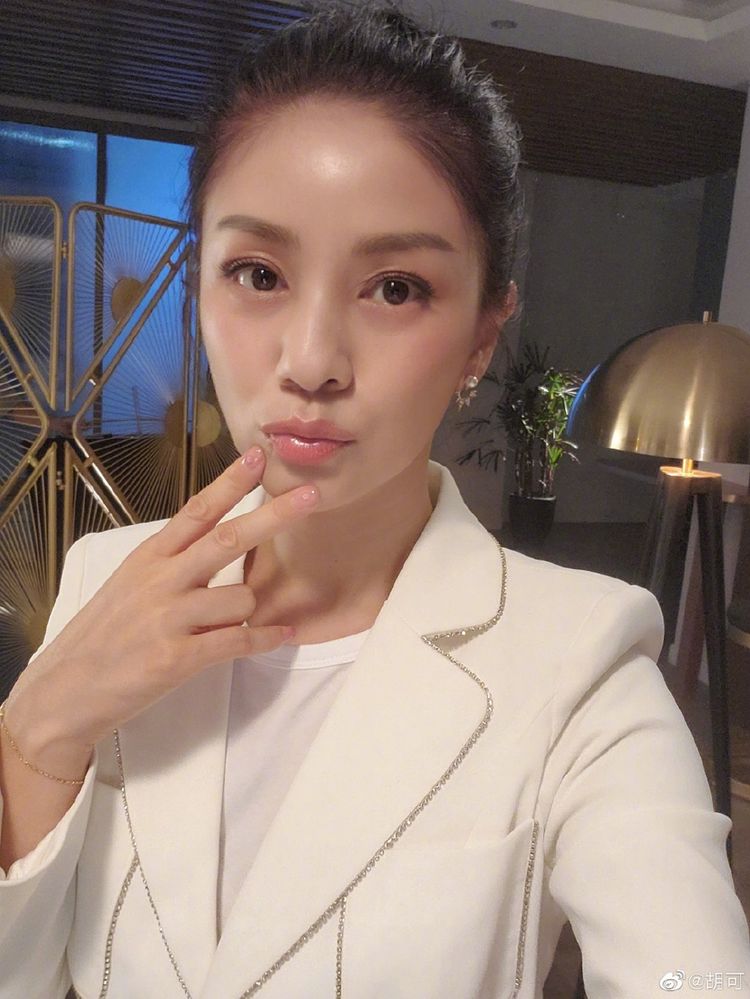 照片中,胡可或是扎起头发,戴着圆框眼镜;或是手撑下巴,笑容甜美,少女