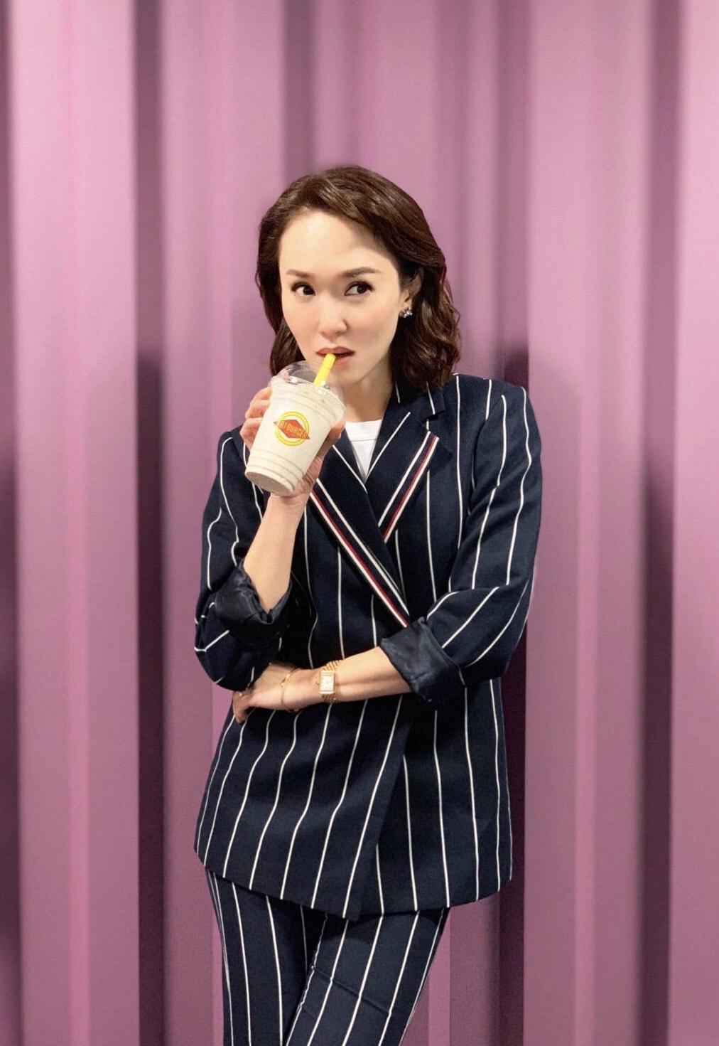 范文芳是个有品位的女人,穿条纹套装出席活动干练利落,精致高级